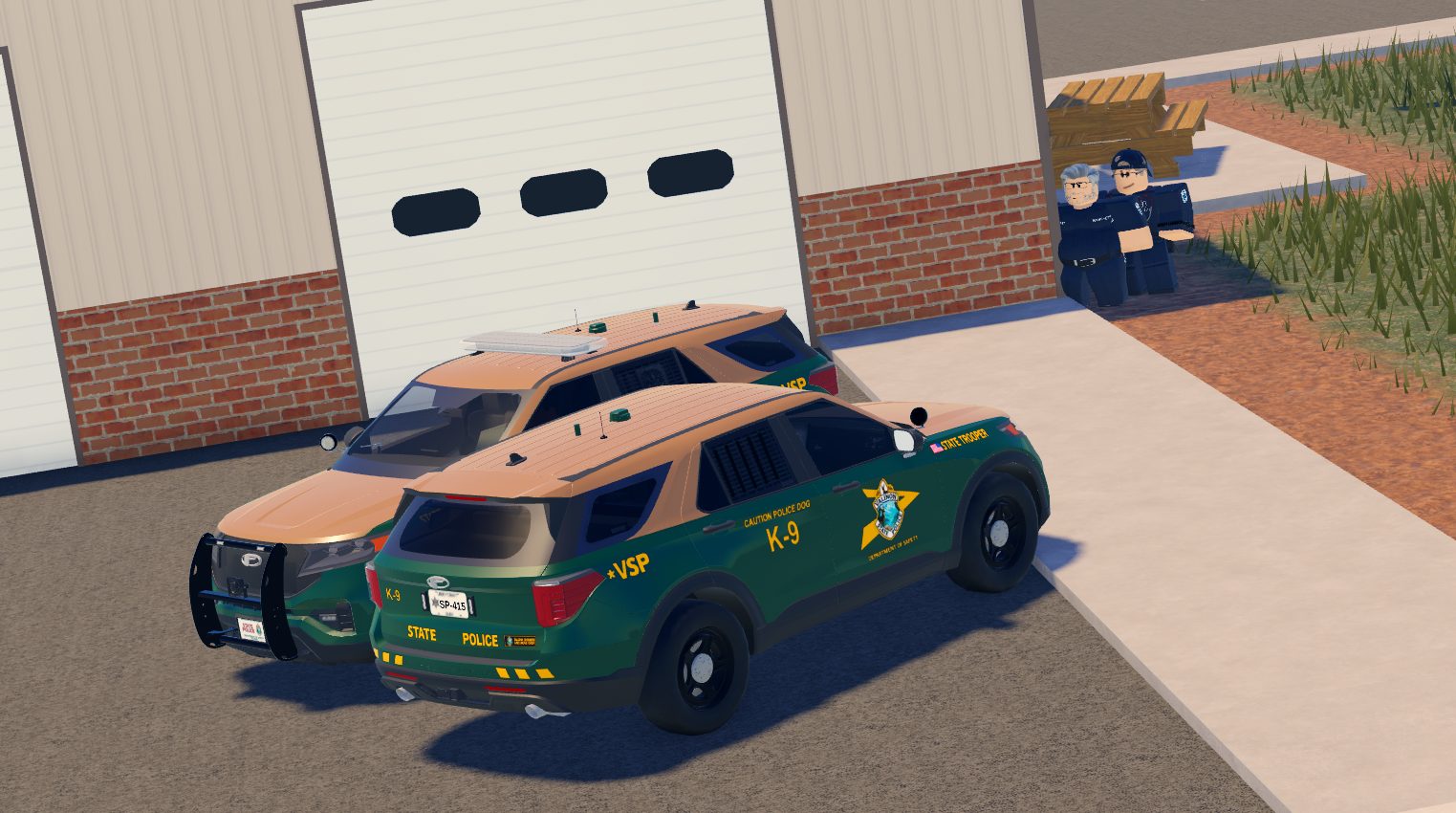 State Police K-9 units outside a station garage.